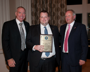 Image of Will Brewer receiving a plaque from the Arkansas State Police.